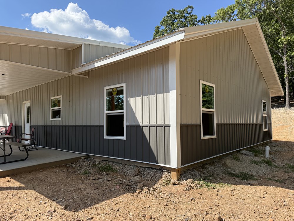 Greers Ferry barndominium corner view showing the wainscot break and the covered end porch.